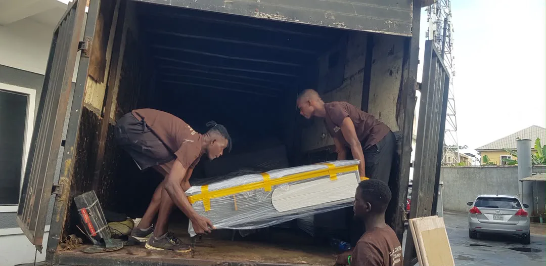 Moving crew loading wrapped furniture into a truck